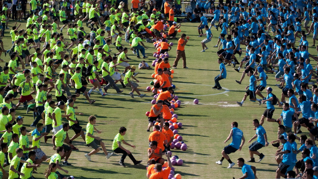 Students rushing to the center of the field to grab dodgeballs
