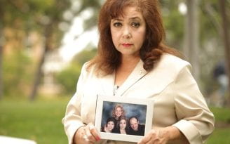 Frances Saldaña with a photo of her family
