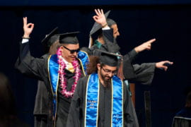 Graduates celebrating onstage