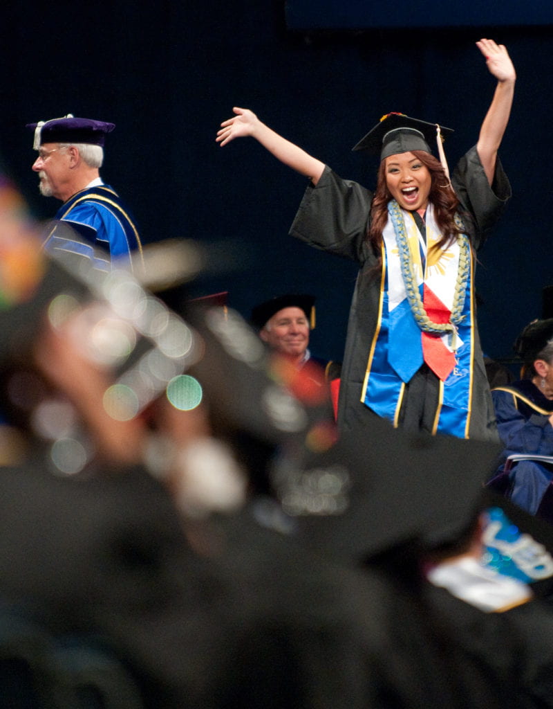 A graduate celebrating at Social Ecology Commencement