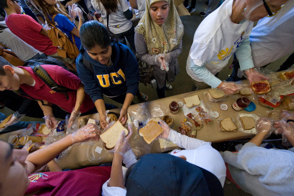 Volunteers make sandwiches for the needy