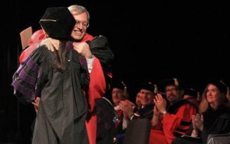 Dean Erwin Chmerinsky hugs graduate Jean Su