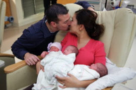 Steven gives Angie a kiss while the triplets sleep in her arms