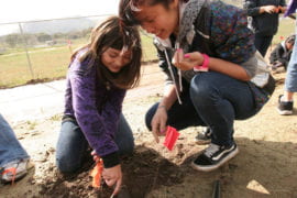 Lauren Wong helps Luiseno tribe member Grace Galvin plant a garden on the reservation