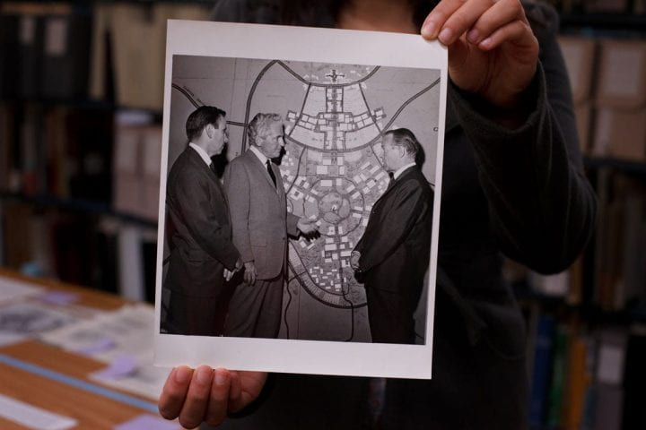 Photograph of architects Ray Watson, William Pereira and an unidentified man with a schematic of UCI