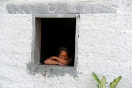 A woman with Down syndrome gazes out a window in Joyas de Carballo