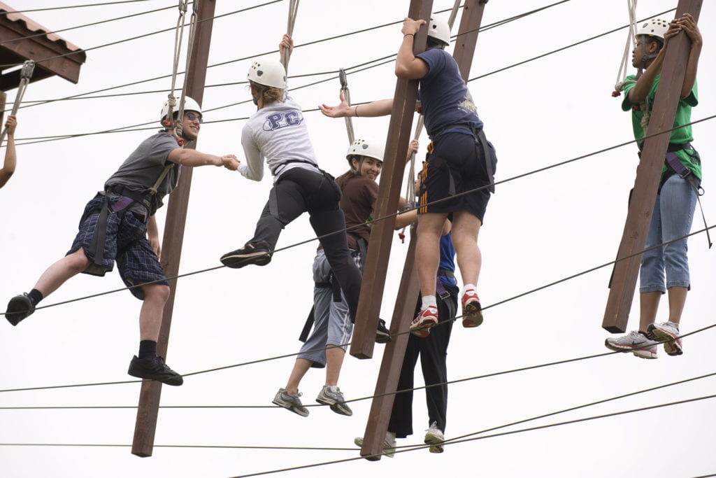 A team crossing the rope course