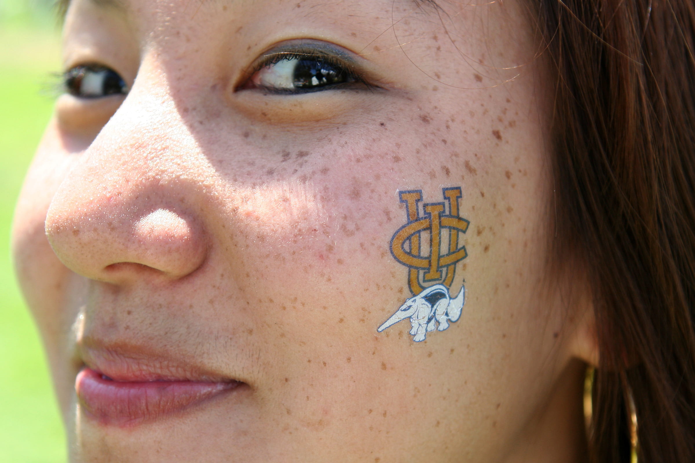 Student with a UCI tattoo on their cheek