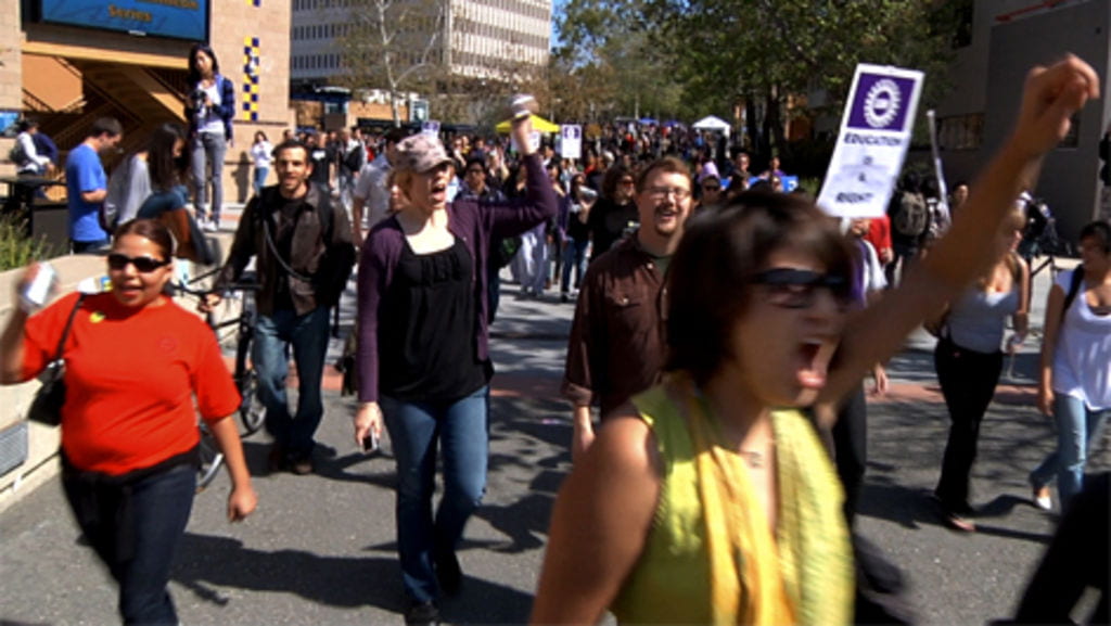Students protesting state budget cuts to education march on UCI’s Ring Mall during March 4’s “Day of Action.”