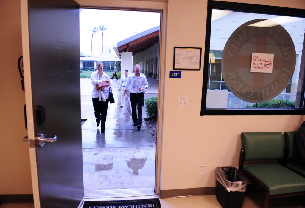 Dodging rain drops, UC Irvine health sciences students arrive to start their day at the clinic