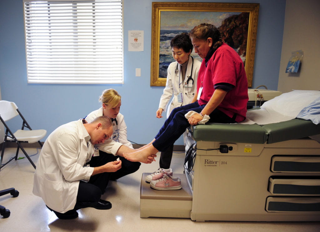 With advice from Dr. Emily Dow, medical students Scott Kendall, left, and Heather Sand examine Maria del Carmen Ortiz