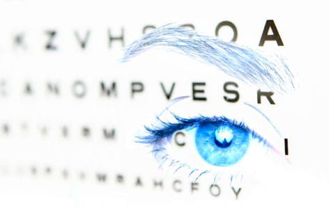 An eye with vision test letters projected on top