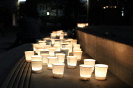 students place candles at the stage of UC Irvine Student Center