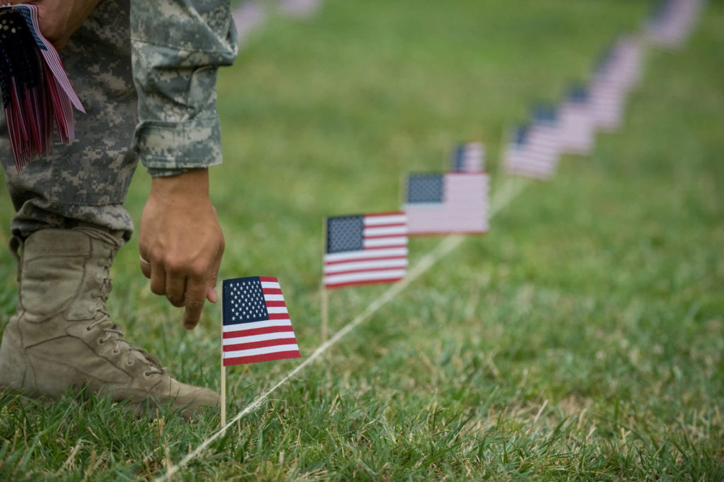 An ROTC student helping to setup flags