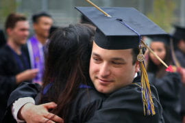 Drama grad Avi Wilk hugs a fellow graduate