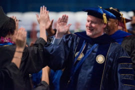 Chancellor Howard Gillman high fives newly-minted grads