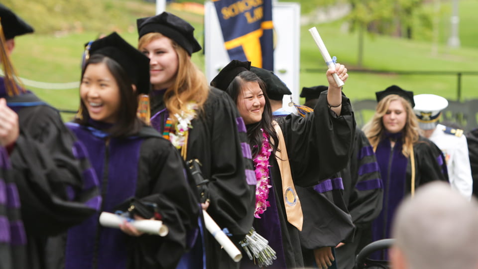 Jubilant UCI law school graduates exit their May 9 commencement ceremony in Aldrich Park