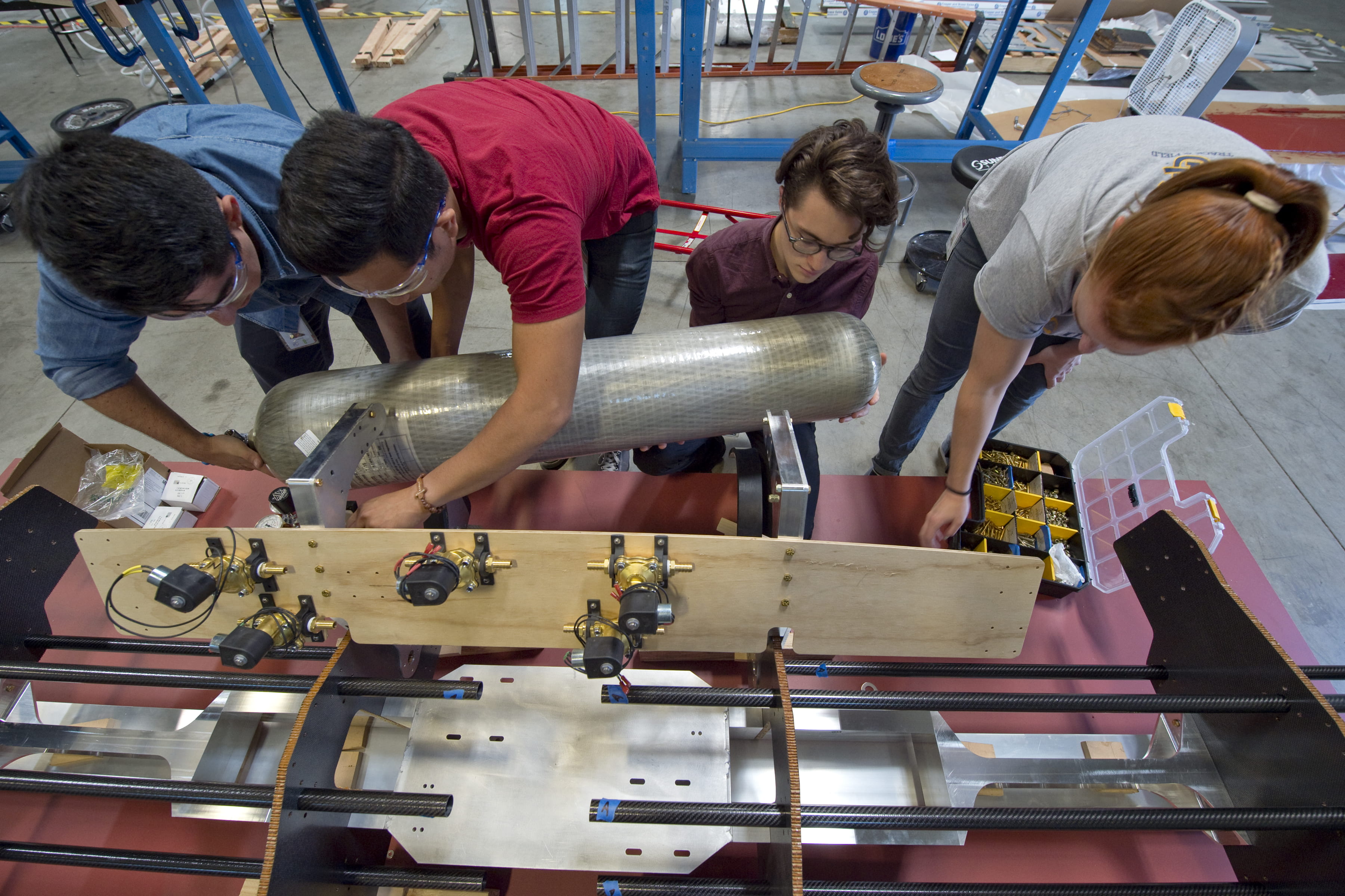 Guzman, Buenviaje, Guerrero and mechanical engineering senior Madelyn Sando (from left) fit an air tank into the pod.