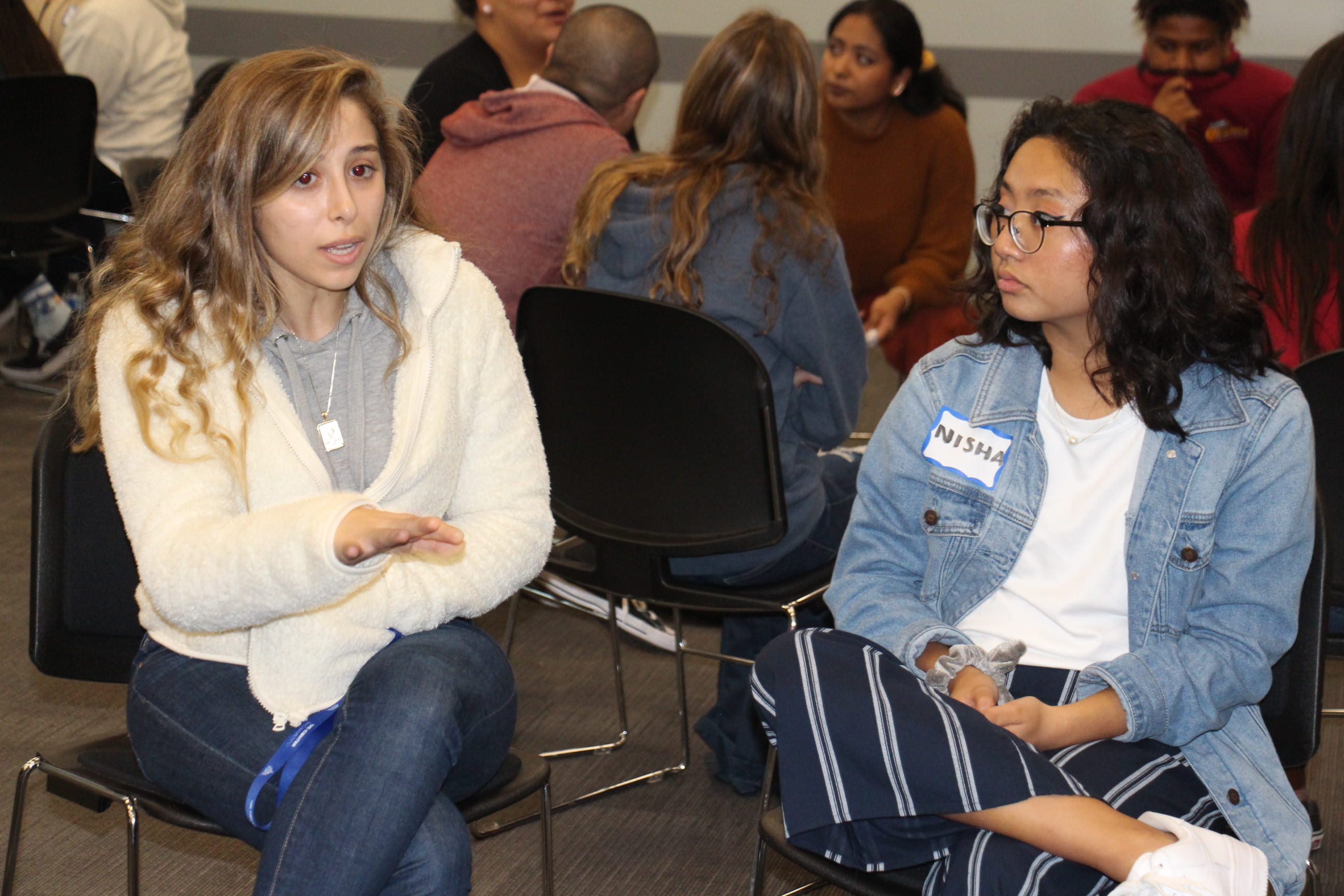 Nora Beik (left), an international studies and political science major at UCI and a student leader in the Diversity, Inclusion & Racial Healing Ambassador Program, chats with a local high schooler.