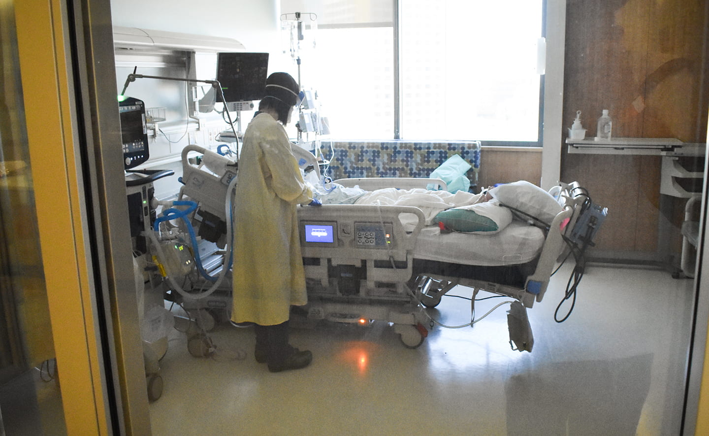 Nurse attending to a patient in a hospital room.