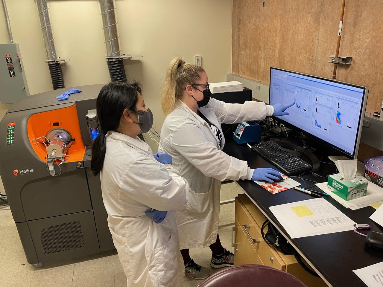 Vanessa Scarfone (left), flow & mass cytometry core manager at the Sue & Bill Gross Stem Cell Research Center, and research associate Pauline Nguyen analyze data from the first Helios experiment.