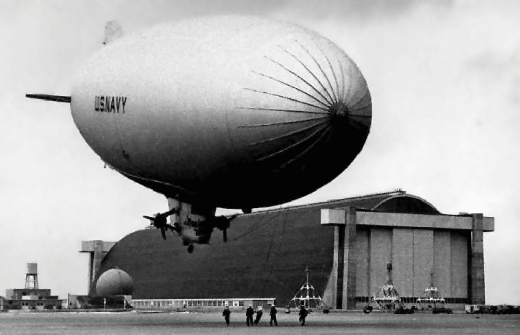 A U.S. Navy blimp hovers near one of the massive airship hangars at the Naval Air Station Santa Ana (later the Marine Corps Air Station Tustin) in this exhibit photo from 1943. 