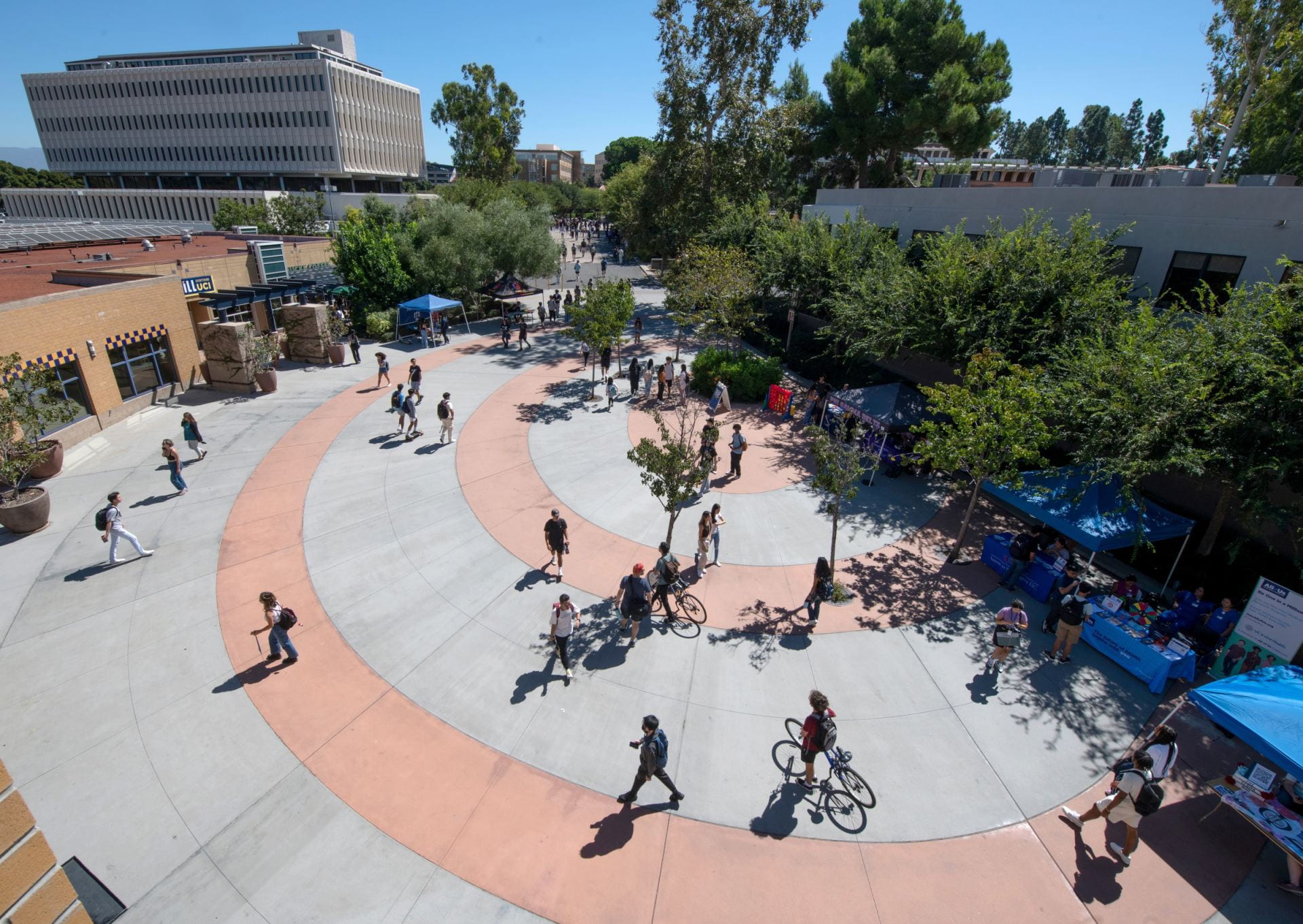Students walking and biking on the UCI campus.