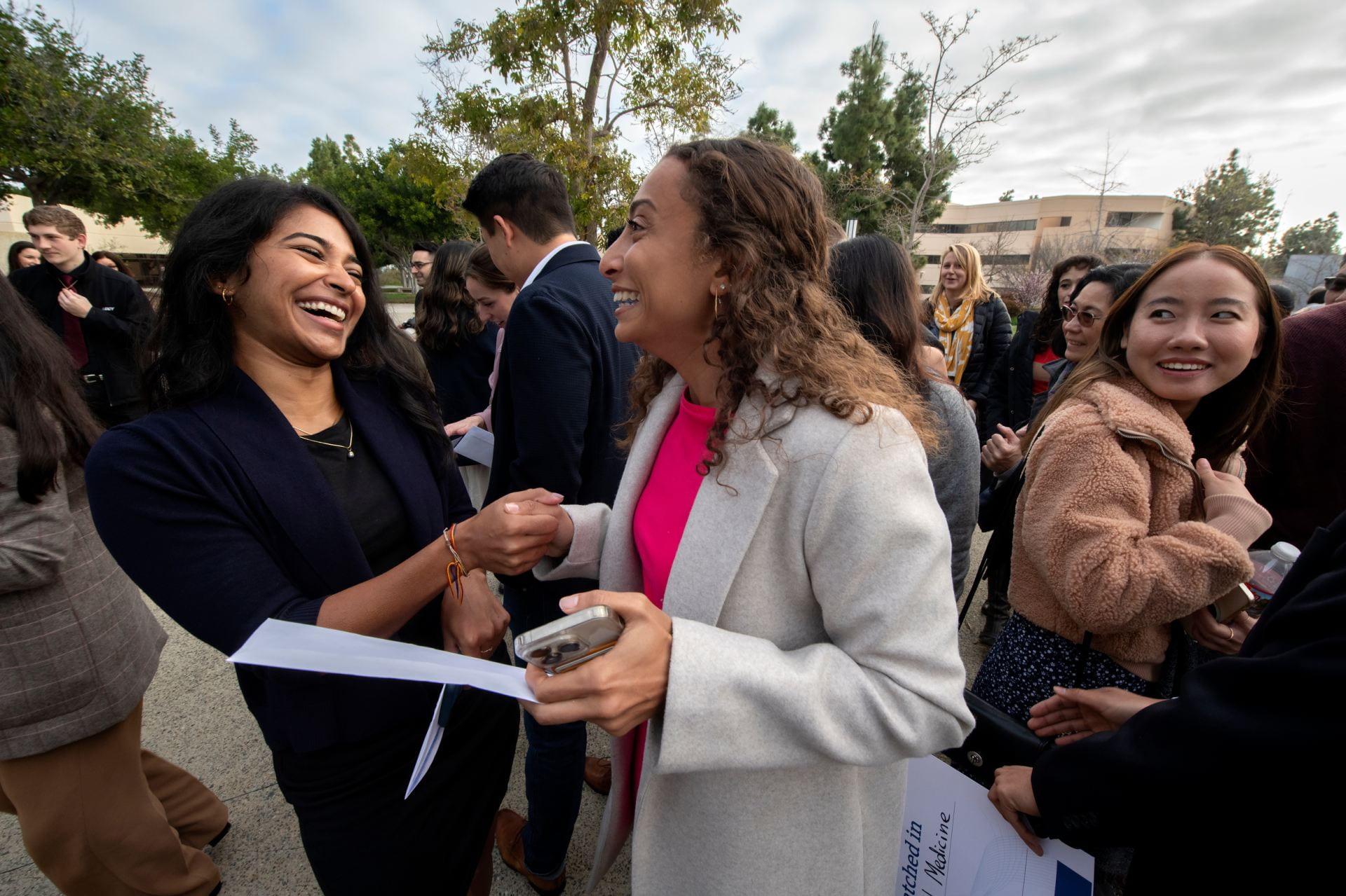 Meril Tomy (left) and fellow medical student Marihan Attiah congratulate each other after learning at UCI’s Match Day ceremony where they’ll serve their residencies.