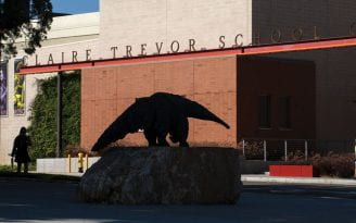 Shadow of Anteater statue with Claire Trevor School of the Arts signage in the background.
