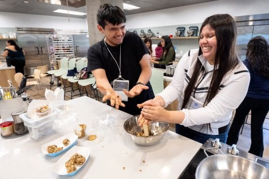 Orange County high school students enjoy making energy bites under the direction of Chef Jessica VanRoo in the Susan Samueli Center for Integrative Health kitchen.