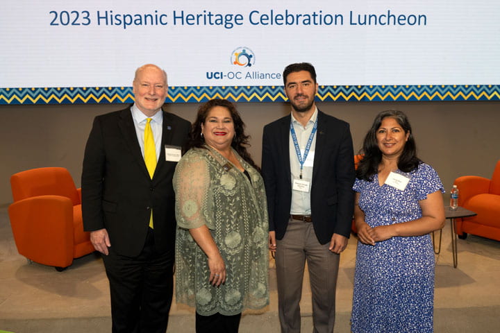 A group of people standing in front of a screen that reads 2023 Hispanic Heritage Celebration Luncheon
