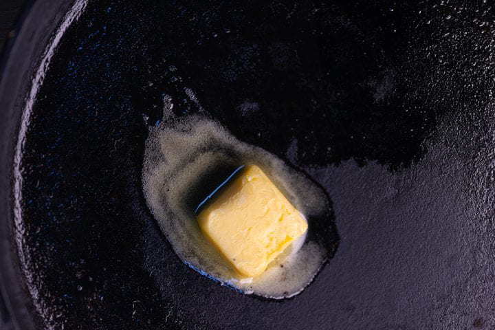 Melting in a cast iron pan is a pat of butter derived through a chemical process.