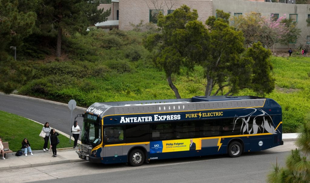 An electric bus pulls up to stop on W. Peltason Dr. on the UCI campus.