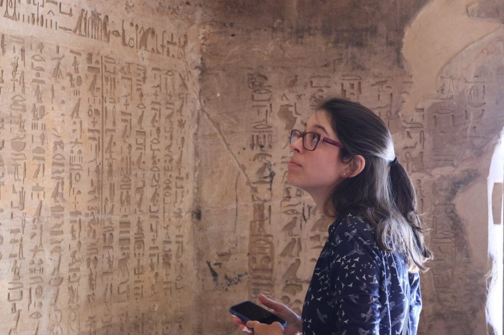 At the ancient Egyptian tomb of Ahmose, son of Ibana, Luiza Osorio G. Silva, a UC Irvine assistant professor of art history reads the deceased’s autobiography.