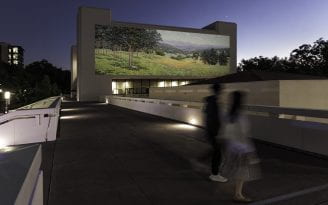 This rendering of the “Plein-Air en Plein Air” installation features an image of Granville Redmond’s painting “California Landscape with Flowers,” circa 1931, oil on canvas, 32 x 80 in., projected onto the Social Science Lab building. The artwork is a gift from The Irvine Museum to UC Irvine’s Jack and Shanaz Langson Institute and Museum of California Art.
