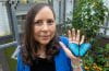 Adriana Briscoe, UC Irvine professor of ecology and evolutionary biology with a blue butterfly on her hand.