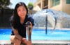 Sunny Jiang, UC Irvine professor of both civil and environmental engineering and ecology and evolutionary biology sitting in front of a fountain holding a clear water bottle.